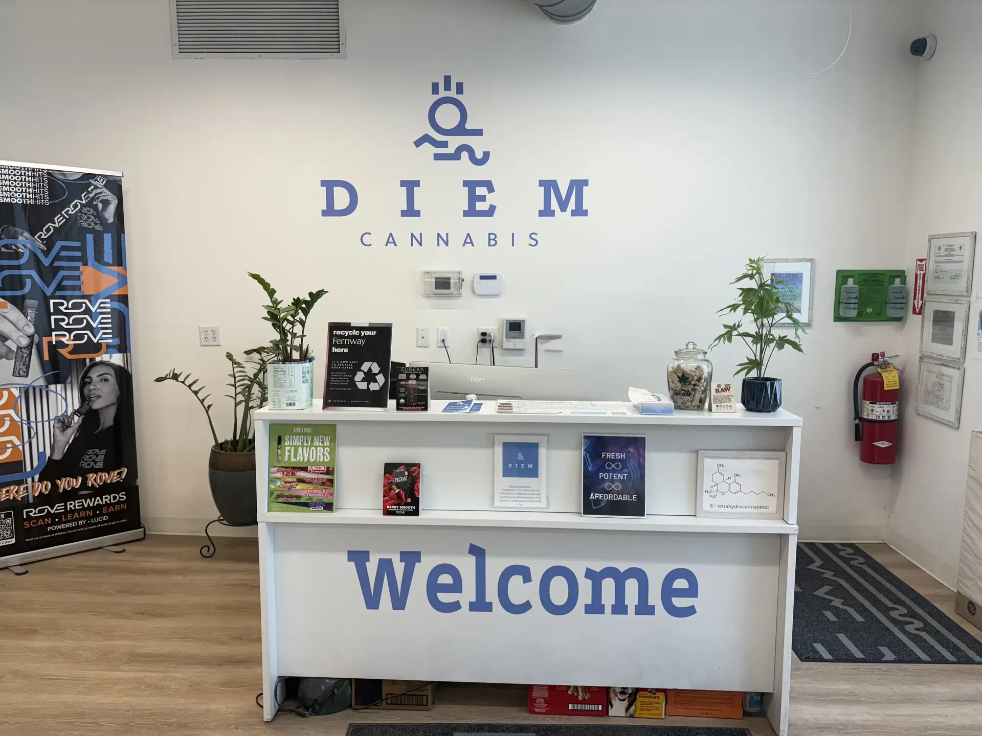 Diem's welcome desk under the blue Diem Cannabis logo